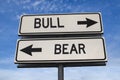 Bull vs bear. White two street signs with arrow on metal pole with word
