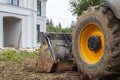 bulldozer is being prepared to demolish an illegally built private house in natural area. Close - up photo of tractor bucket in Royalty Free Stock Photo