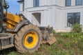 bulldozer is being prepared to demolish an illegally built private house in natural area. Close - up photo of tractor bucket in Royalty Free Stock Photo