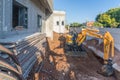 Bulldozer and brick and concrete house under construction