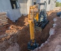 Bulldozer and brick and concrete house under construction