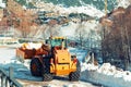 A bulldozer with chains on wheels removes snow in a village in the mountains of Andorra.