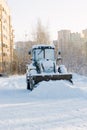 Bulldozer covered by snow on cold winter street