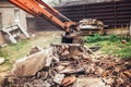 bulldozer on demolition site working on building and loading bricks and concrete into dumper trucks