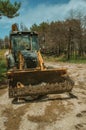 Bulldozer on a dirt road in a burnt forest