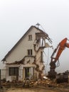 Excavator demolishing old residential building