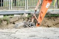 Bulldozer excavator machinery digging a ditch on the street for the new pipeline.