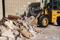 Bulldozer excavator shoveling debris into pile with his ladle