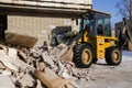 Bulldozer excavator shoveling debris into pile with his ladle