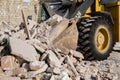Bulldozer excavator shoveling debris into pile with his ladle
