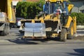 Bulldozer with forklift discharges concrete curbs