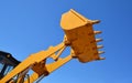 Bulldozer lifting bucket. Yellow excavator bucket against blue sky Royalty Free Stock Photo