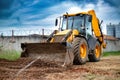A bulldozer or a loader is actively digging dirt in front of a sturdy barbed wire fence, showcasing industrial activity and