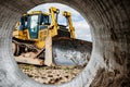 Bulldozer machine is leveling construction site. Earthmover with caterpillar is moving earth. Close-up. Construction heavy Royalty Free Stock Photo