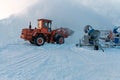 A bulldozer makes a hill of snow with an iron bucket. Artificial snow is made with snow cannons. Royalty Free Stock Photo