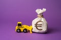 A bulldozer pushes a euro money bag.