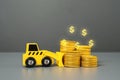 Bulldozer and a stack of coins. Deposits and savings. Invest in the project. Lose money. Confiscation and freezing of assets. Royalty Free Stock Photo