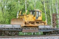 Bulldozer stands on the railway transporter. Royalty Free Stock Photo