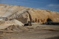 Bulldozer in the stone quarry in the middle of the day.