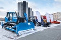 Bulldozer and wheeled tractor with mouldboard at an industrial exhibition at winter Royalty Free Stock Photo