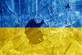 Bullet hole, cracks in the glass on a yellow-blue background. Ukraine flag on broken glass texture. Concept, Russian-Ukrainian war