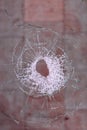 Bullet hole in the glass on a blood red background Royalty Free Stock Photo