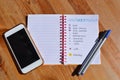 Bullet journal, pens and cellphone on desktop Royalty Free Stock Photo