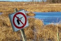 Bullet ridden sign along a wildlife pathway