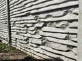 Bullet-riddled concrete corrugated fence in receding perspective