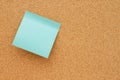 Bulletin board with a blank teal sticky note Royalty Free Stock Photo