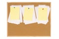 Cork bulletin board with untidy torn notepaper and yellow post-it style sticky notes Royalty Free Stock Photo