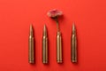 Bullets and cartridge case with beautiful flower on red background, flat lay Royalty Free Stock Photo