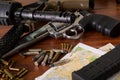 Bullets and a firearm. Bullets are a projectile expelled from the barrel of a firearm over a map, on wooden table