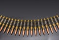 Bullets of linked ammunition lined up in row on a black background. Royalty Free Stock Photo