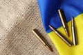 Bullets and national Ukrainian flag on burlap, flat lay. Space for text Royalty Free Stock Photo