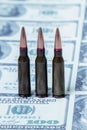 Bullets on US Dollar bills as symbol of bloody business, military conflicts and murders. Vertical image