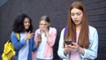 Bullied female student reading embarrassing news social networks by smartphone Royalty Free Stock Photo