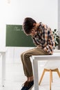 Bullied schoolchild sitting on table covering Royalty Free Stock Photo