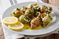 Bulots Cuits - Cooked Waved Whelks with a sauce of butter, garlic and parsley, lemon close-up. Horizontal