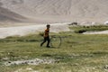 Bulunkul, Tajikistan, August 23 2018: A child plays with an old rim