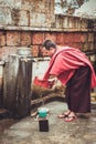 Bumthang, Bhutan - September 14, 2016: Monk washing dishes near Kurjey Lhakhang (Temple of Imprints) in Bumthang valley, Bhutan Royalty Free Stock Photo