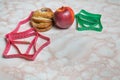 Bun, apple and two measuring tapes. Healthy and unhealthy food con Royalty Free Stock Photo