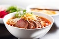 Bun Bo Hue, AI generative Vietnamese spicy beef noodle soup made with vermicelli noodles, beef shank, and lemongrass