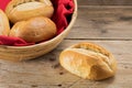 Bun and bread rolls in a basket with red napkin on old wood Royalty Free Stock Photo