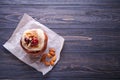 Bun with cream, cherries, almonds and cinnamon on wooden background with place for text Royalty Free Stock Photo