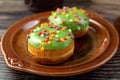 Bun, donut covered with glaze. Tutti frutti bun on a plate. Sweet pastries. Dessert. Still life. Close-up. Royalty Free Stock Photo