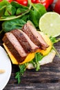 Bun with grilled roast beef, mango and arugula. Royalty Free Stock Photo