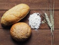 Bun and a loaf of white bread, flour and wheat ears lying on wo Royalty Free Stock Photo