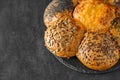 Bun with sunflower seeds, flax seeds, poppy seeds and baked cheese, on dark background, selective focus Royalty Free Stock Photo