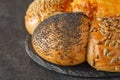 Bun with sunflower seeds, sesame seeds, poppy seeds and baked cheese, on dark background, selective focus Royalty Free Stock Photo